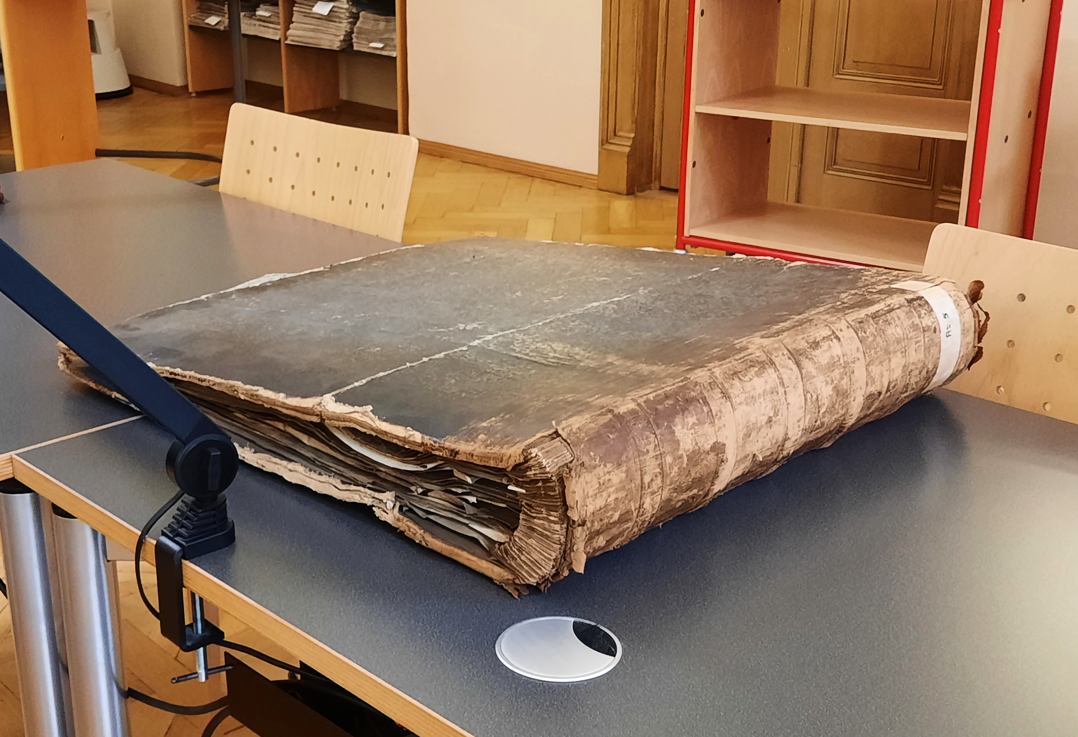 20241022_110709_zugeschnitten Der Atlas mit der Signatur AT 5. Von außen werden Einbandschäden sichtbar.